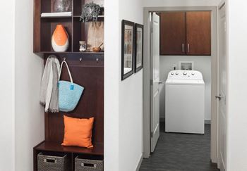 A bathroom with a white sink and a brown cabinet.